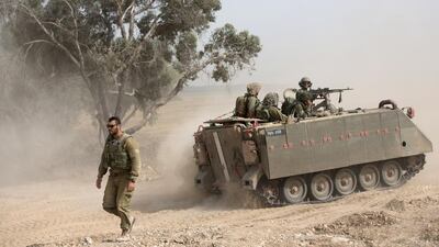 Israeli soldiers drive an armored personal carriers during a training exercise near the Gaza Border. Menahem Kahana / AFP