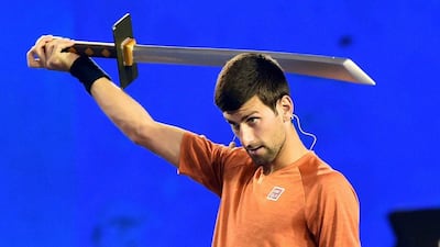 Novak Djokovic holds a novelty sword during a Kids Day exhibition at Rod Laver Arena on Saturday. Julian Smith / EPA