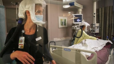 Registered nurses Lindsey Ryan and Carrie Tang provide post-mortem care to a deceased Covid-19 patient at Sharp Grossmont Hospital on December 14, 2020 in La Mesa, California. AFP