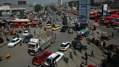 People and vehicle move past in a busy bazaar during a lockdown during Ramadan in Kabul. AP