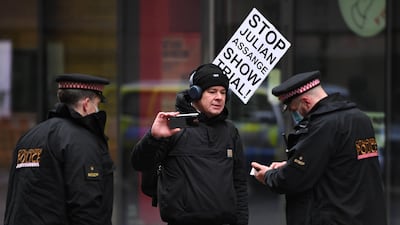 Police speak to a man who appears to be filming as Julian Assange is taken to the Old Bailey. Getty Images