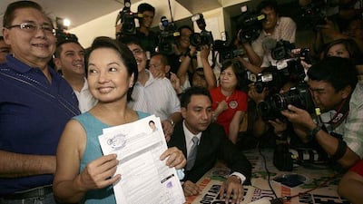 Gloria Macapagal Arroyo, the president of the Philippines, with husband Mike, left, at the election commission office near Manila yesterday.