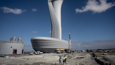 Workers walk in front of the control tower at Istanbul's new airport on October 6, 2018, weeks before its official opening. Getty Images