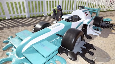A worker sets up a melted F1 car at the main grandstand area, where activities will be held for spectators attending the race. Chris Whiteoak / The National