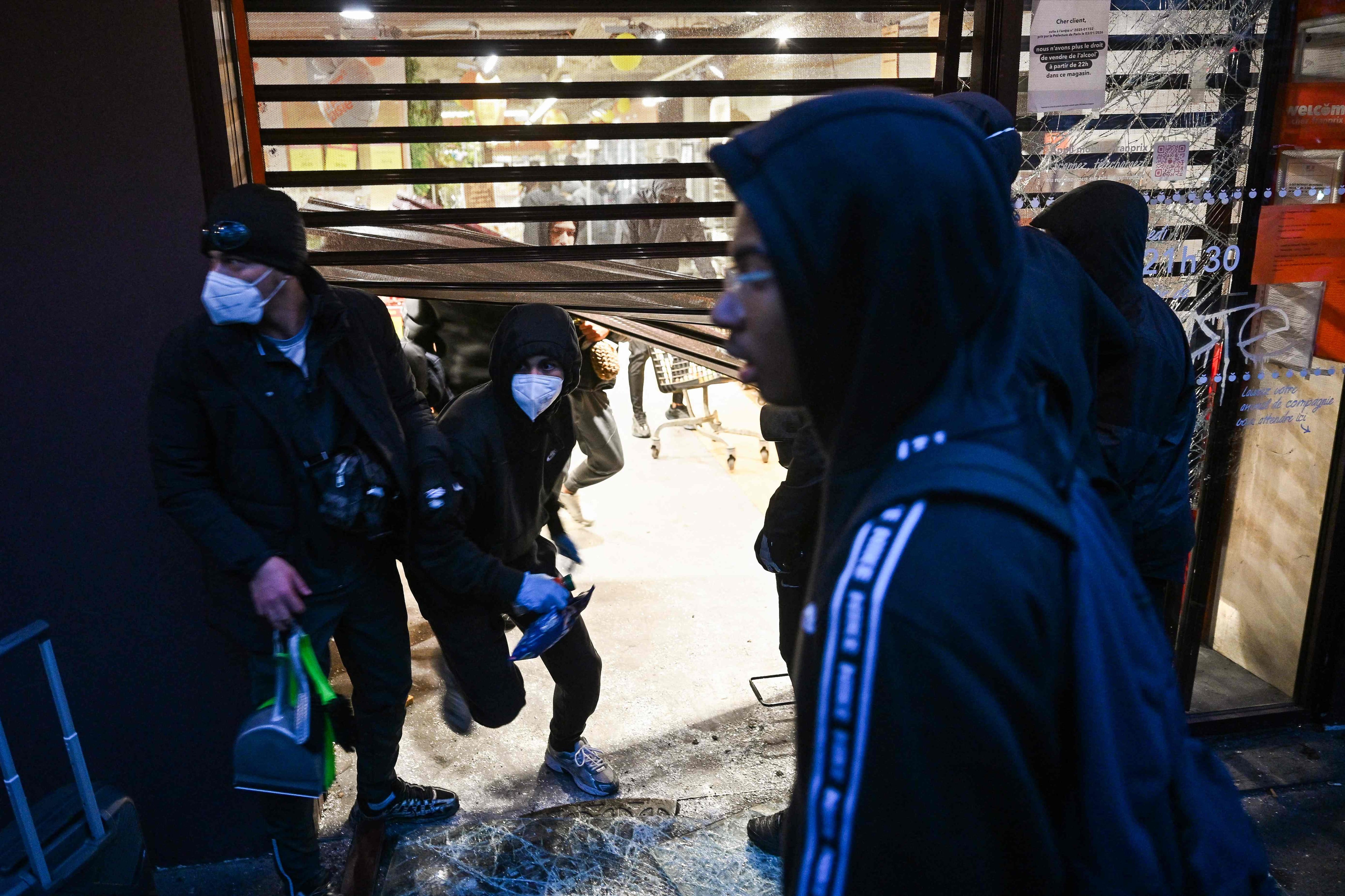 People enter a ransacked Franprix store, in central Paris. AFP