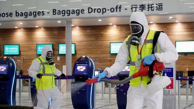 A worker in protective gear sprays disinfectant at Paris-Orly Airport on its re-opening. Reuters