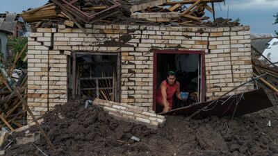 A woman recovers an item from the damaged home of her elderly neighbour after a Russian missile strike yesterday in Druzhkivka, in Ukraine's Donetsk enclave. AP