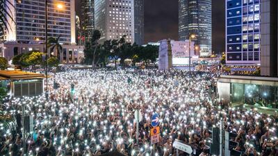 Demonstrators use smartphone flashlights during a rally organised by civil servants at Chater Garden in the Central district in Hong Kong, China. Getty