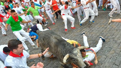 Participants fall next to a Cebada Gago fighting bull. Ander Gillenea / AFP