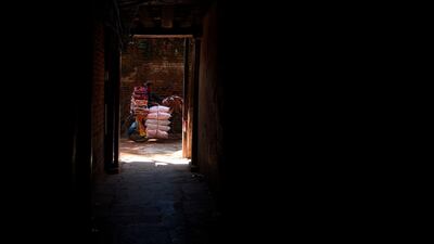 A vendor pushes his bicycle through an alley as he sells bed sheets in Kathmandu. AFP