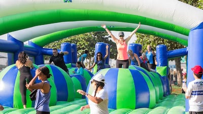 People climb over the "Bounce Off" obstacle. Leslie Pableo for The National