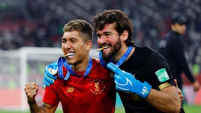 Liverpool's Roberto Firmino and Alisson celebrate winning the Club World Cup. Reuters