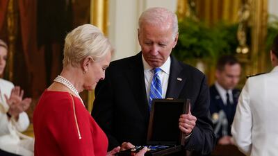 Ms McCain accepts the medal on behalf of her late husband John. AP