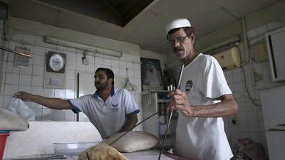 Kashmiri baker Ghulam Fareed, right, prepares tandoori naan at his brother’s bakery in Abu Dhabi. Silvia Razgova / The National
