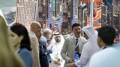 Delegates chat on the first day of Annual Investment Meeting in Dubai. Pawan Singh / The National