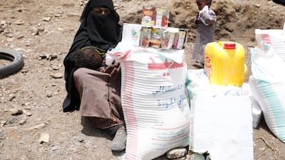 A displaced Yemeni woman receives emergency food on the outskirts of Sanaa, Yemen. EPA