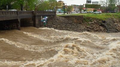 Water rushes under a bridge in downtown Hattiesburg, Mississippi, following heavy storms. Hattiesburg American / AP Photo