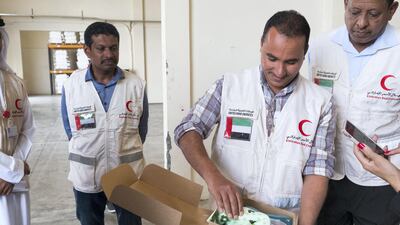 An Emirates Red Crescent worker shows a package for children that includes a blanket and toys. Anna Nielsen for The National