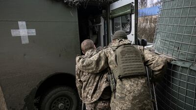 A medic helps an injured soldier into an evacuation ambulance in the Donbas region. Getty