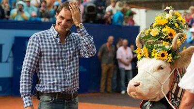 Roger Federer, standing next to his cow 'Desiree' during a welcome ceremony at the Suisse Open in Gstaad, is making alterations to his playing schedule. Peter Schneider / EPA