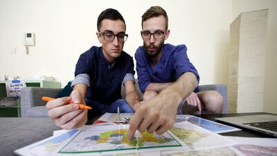 William Harbidge, left, and David Knapp map out their Mongol Rally route on July 9, 2015, at home in the Khalifa City area villa of Abu Dhabi. The pair and a friend will take part in the month-long overland road trip from London to Ulan Bator, Mongolia. Christopher Pike / The National