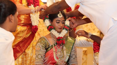 A garland of flowers is placed on the bride's neck as part of the ceremony