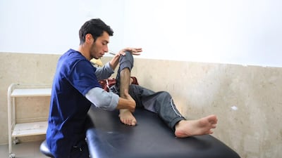 A physiotherapist treats an injured patient at a field hospital in Khan Younis, southern Gaza. Photo: Mohammed Abu Doon