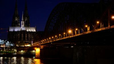 The Cologne Cathedral, a UNESCO World Heritage Site, next to the Hohenzollern railway bridge across the river Rhine, is partly illuminated during Earth Hour in Cologne, Germany, March 23, 2024. REUTERS / Jana Rodenbusch