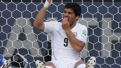 Luis Suarez holds his teeth after apparently biting Giorgio Chiellini in Uruguay's 1-0 win over Italy on Tuesday at the 2014 World Cup in Natal, Brazil. Yves Herman / Reuters / June 24, 2014