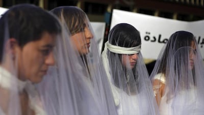 About a dozen Lebanese women – dressed as brides in white wedding gowns stained with fake blood and bandaging their eyes, knees and hands – stand in front of the government building in Beirut, Lebanon, on December 6, 2016 to protest against a Lebanese law that allows a rapist to get away with his crime if he marries his victim. Bilal Hussein/AP Photo