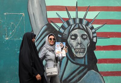 An Iranian woman holds a poster of Maj Gen Qassem Suleimani. EPA