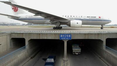 An Air China Boeing 777 crosses a bridge at the Beijing International airpor. Teal Group forecasts demand for big jets will fall. AFP / STR