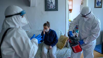 Health workers help a woman who tested positive for the coronavirus, at Bagcilar in Istanbul. AFP