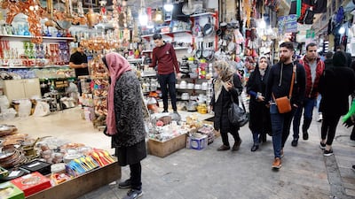 Iranians shop in a bazaar in Tehran EPA