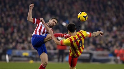 Atletico Madrid captain Gabi, left, vies for the ball with Barcelona's Cesc Fabregas during their Primera Liga match on Saturday. Dani Pozo / AFP