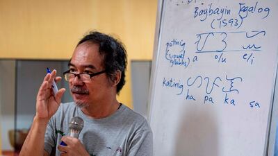 This photo taken on July 6, 2019 shows cultural advocate Leo Emmanuel Castro teaching students the indigenous script known as Baybayin, used before Spanish colonisation in 1521, in Manila.