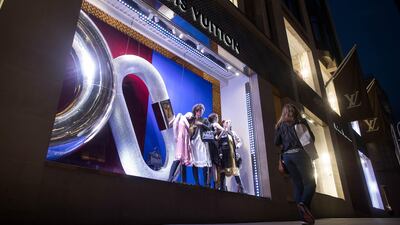 A pedestrian walks past a display of luxury fashion apparel in the window of a LVMH Moet Hennessy Louis Vuitton SE store on New Bond Street in central London, U.K., on Thursday, Aug. 31, 2017. U.K. consumer confidence staged a slight rebound from its lowest level since just after the Brexit vote. Photographer: Simon Dawson/Bloomberg