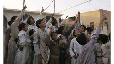 Members of the Abida tribe point to the sky as they look for a drone aircraft flying at very high altitude over Wadi Abida, in the eastern Yemeni province of Maarib. Khaled Abdullah / Reuters