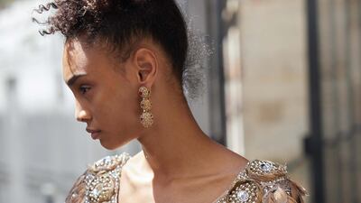 Corset dress with a top embroidered with hand-painted feathers and crystals, and a tulle skirt embroidered with sequins and fringes of canettes, Dolce & Gabbana Alta Moda. Gold filigree earrings, Dolce & Gabbana Alta Gioielleria.
