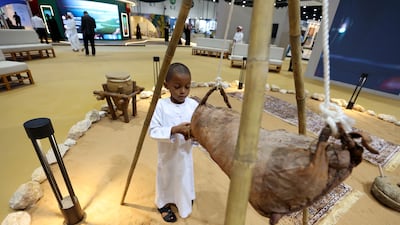Hamdan, who is 5, looks at a zmeel, a leather container used for storing milk