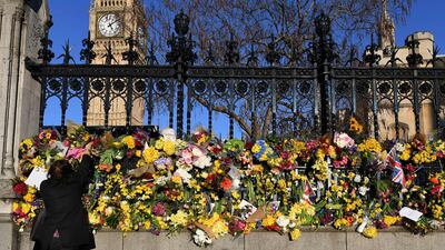 A wellwisher lays flowers outside the Houses of Parliament, following the March 22 attack by Khalid Masood, killing 4, and injuring 29, in London on March 25, 2017. / AFP / Chris J Ratcliffe