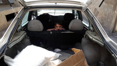 A Syrian boy sits in a car after his family received from the local council aid parcels provided by the UN World Food Programme and the Syrian Arab Red Crescent on May 11, 2016, in the rebel-held village of Saqba, on the eastern outskirts of the capital Damascus. AFP