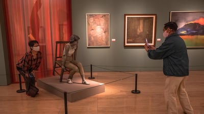 A museum goers snaps a photo of an artwork at the National Art Museum of China on the first day after reopening. EPA