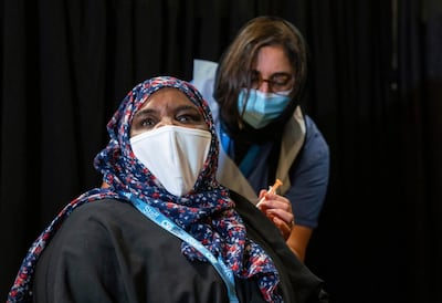 A woman is vaccinated at a London mosque. AP