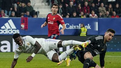 Real Madrid's Brazilian forward Vinicius Junior fights for the ball with Osasuna's Spanish goalkeeper Sergio Herrera. AFP
