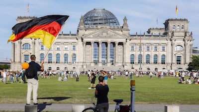 A demonstrator waves a flag in front of the Reichstag building, the seat of the German parliament, following a protest against coronavirus pandemic regulations in Berlin, Germany. EPA
