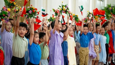 Children wave Emirati and Chinese flags at a state visit reception at the Great Hall of the People.