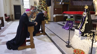 Cardinal Pierbattista Pizzaballa, Latin Patriarch of Jerusalem in the red cap, prays with Auxilliary Bishop of the Latin Patriarchate of Jerusalem William Shomali during a pastoral visit to the Holy Family parish in Gaza city. AFP