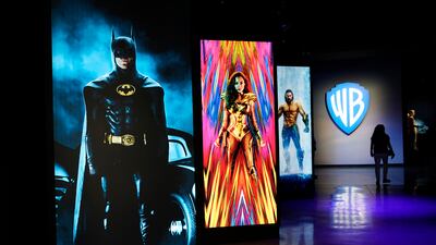 A visitor walks past portraits of DC Comics superheroes as she enters the Action and Magic Made Here interactive experience at the Warner Bros Studio Tour Hollywood media preview.