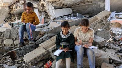 Children in the rubble of destroyed buildings near a tent being used as a make-shift educational centre in Gaza. AFP